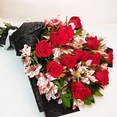 Ramo de 12 rosas rojas con fino follaje de alstroemerias, envueltas en papel negro